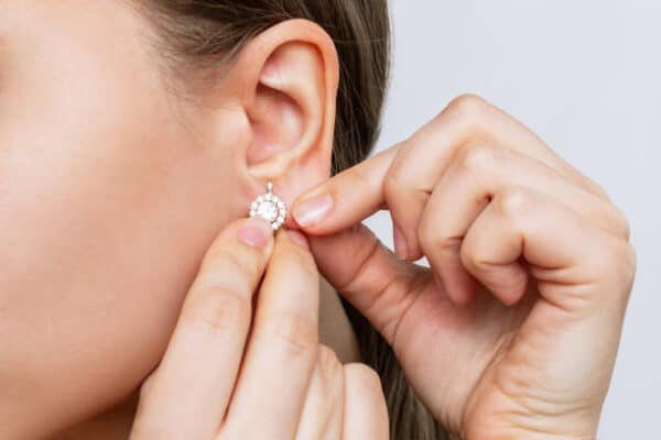 silver earrings 999 on woman ear
